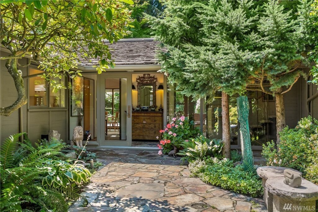Craftsman home with beautifully landscaped stone courtyard and mature tree canopy in Seattle