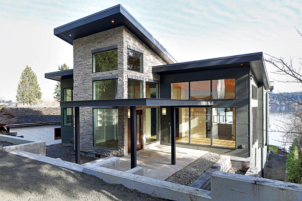 Contemporary custom home with stone and warm-wood cladding and floor-to-ceiling glass in Bellevue, designed by Piper Cole Architects.