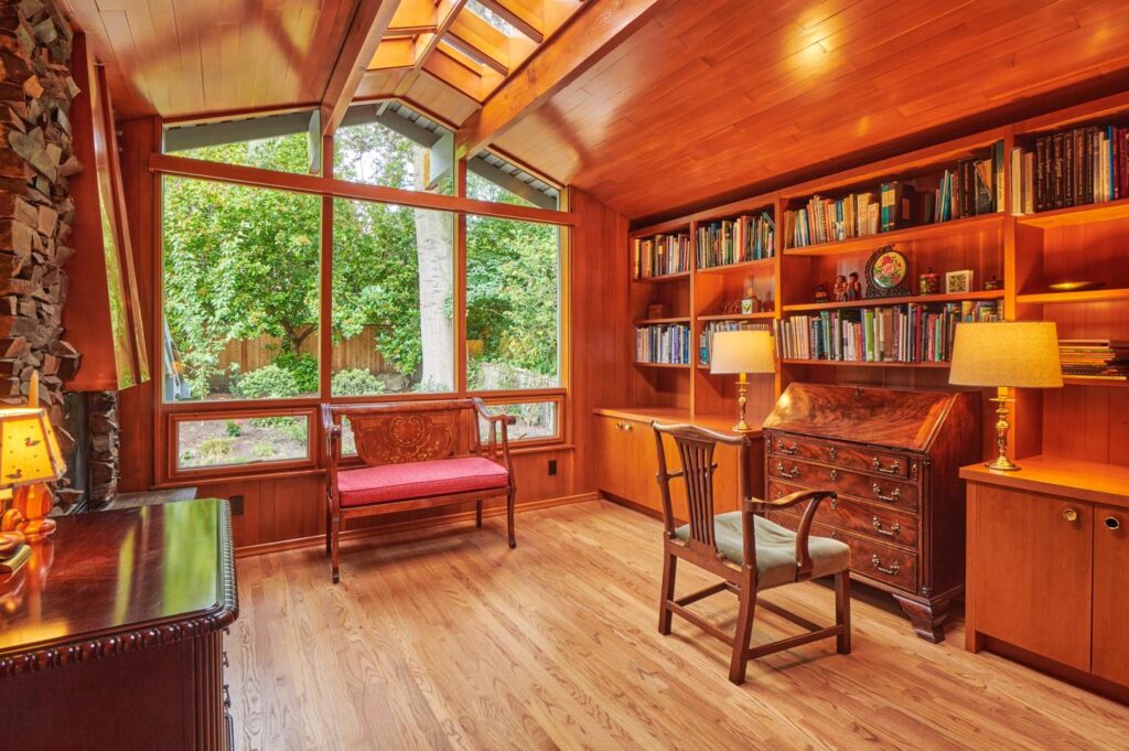Study with cedar ceiling, skylight, built-in bookshelves, stone fireplace edge and garden windows