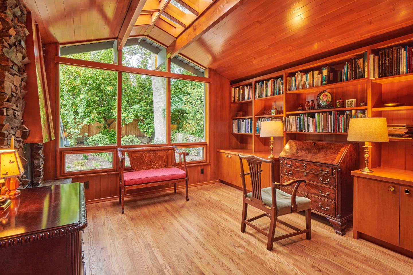 Study with a vaulted cedar ceiling, tall windows and built-in bookshelves