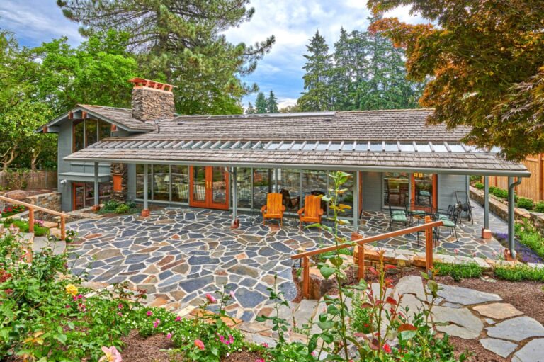Midcentury house with cedar shake roof, long covered patio and flagstone courtyard with garden beds