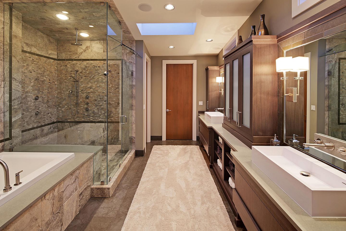 A primary bathroom with a glass steam shower and a wood vanity